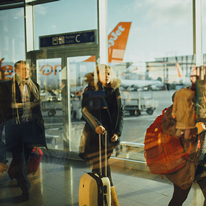 Voyageurs d'affaires sortant de l'avion et marchant dans l'aéroport pour rejoindre le chauffeur VTC Transport Bretagne.